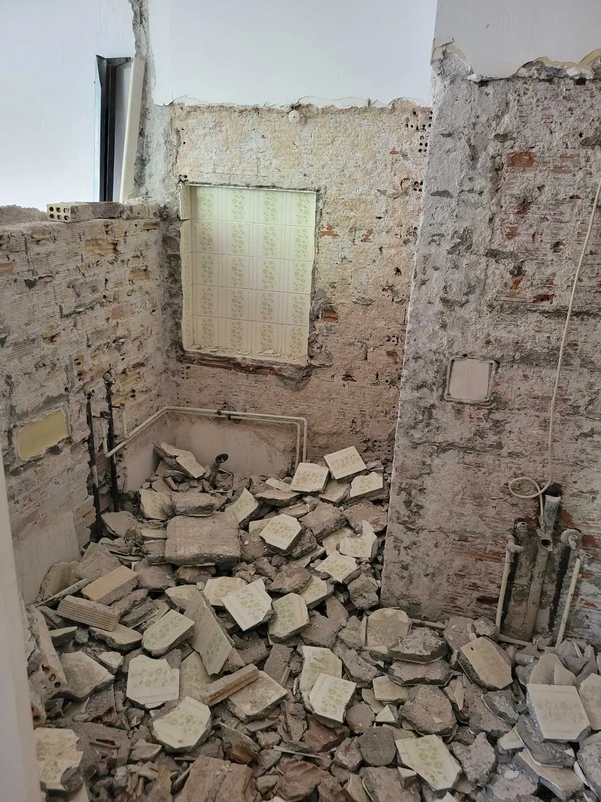 <p>An image of a revamped, contemporary bathroom within a confined space of 50 square feet. The surfaces of the walls are adorned with white subway tiles among which one wall stands out with a lush, vertical garden serving as a natural accent to the overall setting. The showering area sports a pure, minimalist design, enhanced with a baffling obstruction-free glass screen and a rain-imitating showerhead. A compactly designed vanity incorporating a sleek quartz countertop and well-incorporated LED lights reflects modern aesthetics. The floor is festooned with textured, grey porcelain tiles designed for slip resistance, and the overall space is lit up through a proposed overhead skylight for natural illumination.</p>