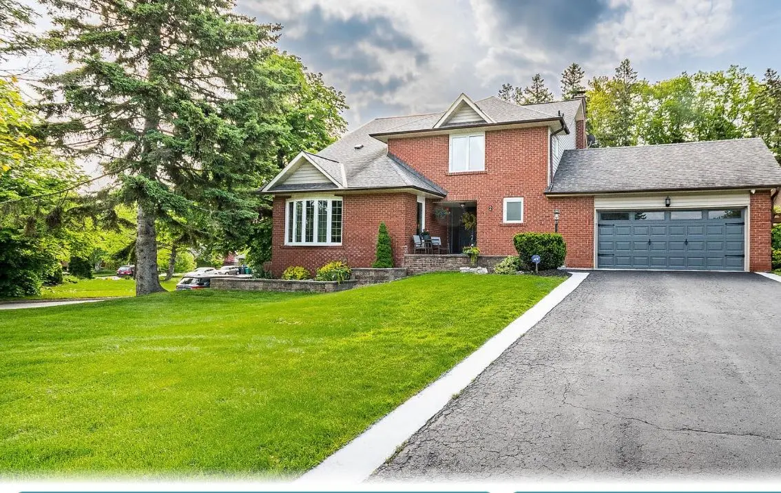 <p>Illustrate a detailed image of a newly renovated front yard and exterior of a house that is around 250 square meters. The residence displays new landscaping, complete with a modern pathway made of stones leading to the front door. To the left, you'll notice raised flower beds teeming with vibrant flora and petite shrubs. The front lawn is impeccably manicured, and near the entrance, there's an inviting wooden bench. The house's facade boasts a fresh layer of light grey paint with white trims accentuating the windows and doors. A stylish, modern garage door replaces the previous old-fashioned one, contributing smoothly to the overall architecture.</p>