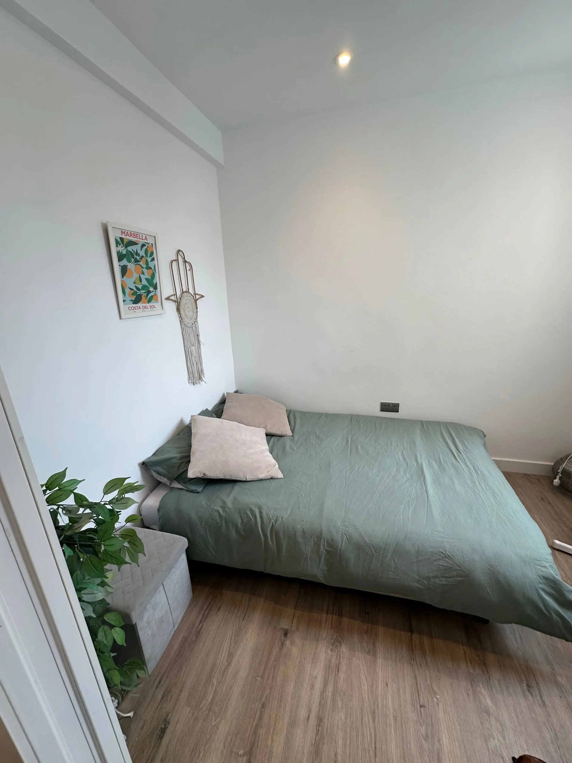 <p>Imagine a cozy bedroom designed in a minimal, modern style. The room is compact, measuring about 10x12 feet. The design showcases a low platform bed adorned with simple, elegant linen, a minimalist desk mounted on the wall, soft lighting emanating from the ceiling, and a vertical greenery feature for a natural touch. The color palette is dominated by soft neutrals with a hint of deep green. The walls are adorned by two modern, abstract art pieces, and tucked in a corner, there's a small reading nook, complete with a comfy chair and a floor lamp. The timeline and budget for this design project are unspecified.</p>