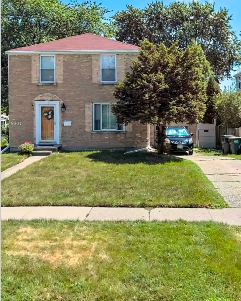 <p>Create an image showing a renovated facade of a two-story brick house. Enhance the landscaping around the house, installing a spacious wooden porch furnished with contemporary items. Replace the old tree with two small, decorative trees. Redesign the driveway with natural stone pavement for a modern look. The front yard should be vibrant with lush grass and a path leading to the front door. Design the house facade to have stylish light fixtures and tasteful house numbers. The facade area should be approximately 30x20 feet.</p>